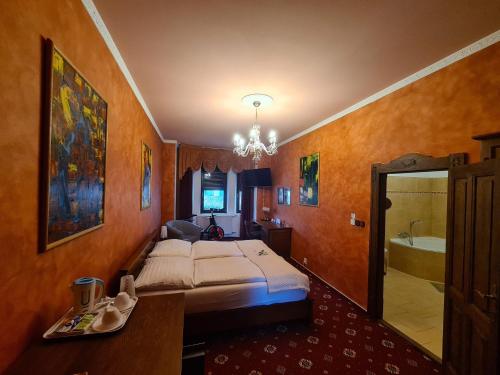a bedroom with a bed and a bathroom with a tub at Brioni Suites in Ostrava