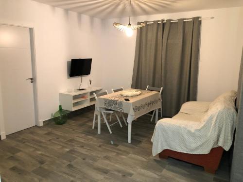 a small white room with a table and a tv at Casa Maria Marta in Cádiz
