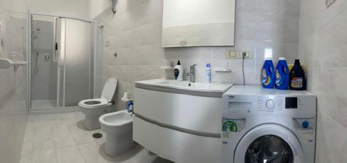 a bathroom with a washing machine and a toilet at OSTUNIRESIDENCE baia camerini in Villanova di Ostuni