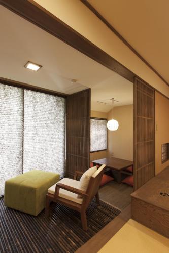 a living room with a chair and a table at Iwaiyado Jyuan Nikko Kawaji onsen in Nikko