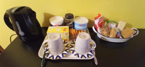 a table with a tray of food and a coffee maker at Via Roma in Terni