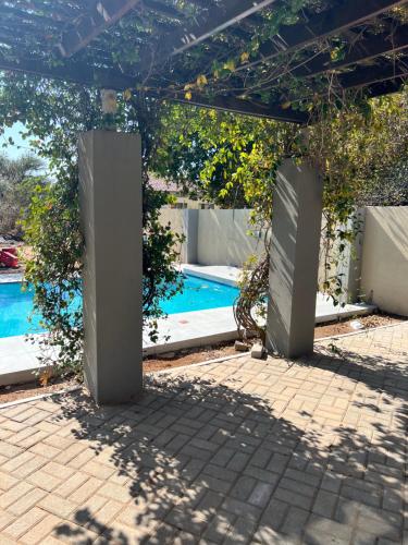 uma pérgola com uma piscina num quintal em Villa 134 Modipane em Gaborone