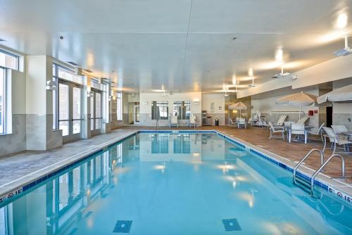a swimming pool with blue water in a building at Hyatt House Naperville/Warrenville in Warrenville