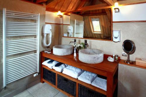y baño con 2 lavabos, espejo y toallas. en Manoir des Indes, The Originals Relais, en Quimper