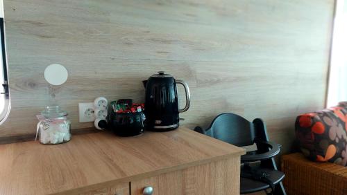 a black coffee maker sitting on top of a wooden counter at Tiny House Miniş in Miniş