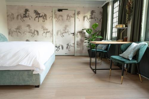 a bedroom with a bed and a table and a wall with horses at Het Heerenlogement Beusichem in Beusichem