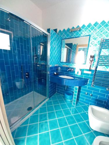 a blue tiled bathroom with a sink and a shower at Hotel Villa Cimmentorosso in Ischia