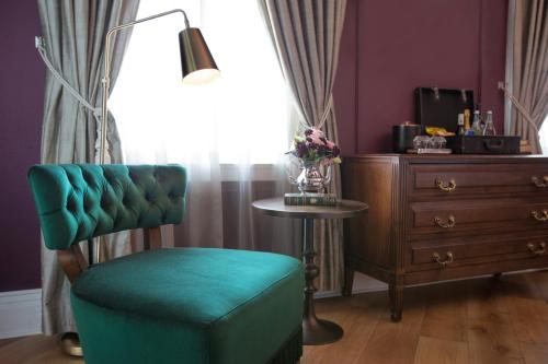 a living room with a green chair and a table at The Culver Hotel in Los Angeles