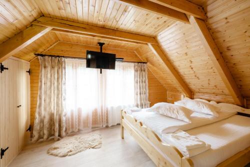 una camera con un letto in una casa di legno di ViiLa Munte Călimani a Topliţa