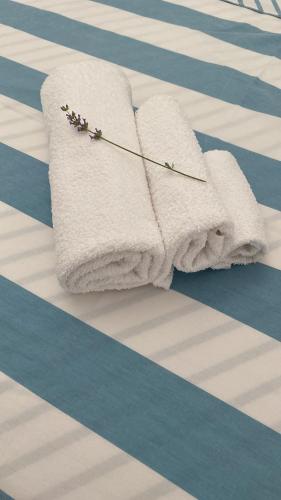 toalla blanca con flores encima de la cama en Apartments Lovor & Lavanda, en Kaštela