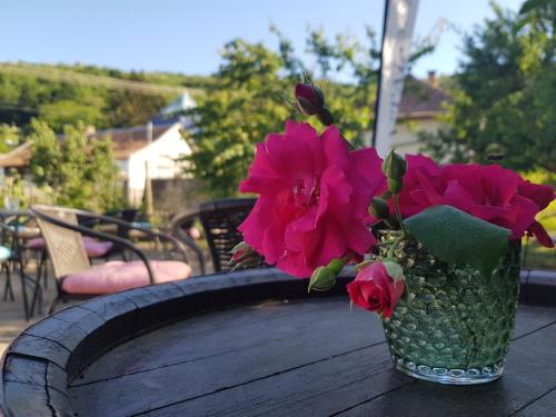 un vaso con fiori rosa seduto su un tavolo di Antalóczy Cottage a Tokaj