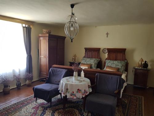 a living room with a table and chairs and a cross at Antalóczy Cottage in Tokaj
