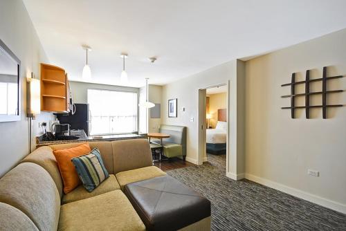 a living room with a couch and a bedroom at Hyatt House Naperville/Warrenville in Warrenville