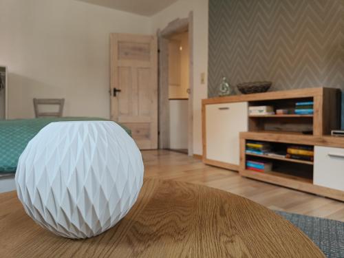 un orbe blanco sentado en una mesa en una sala de estar en Charlys Ferienhaus (ALTSTADT VOLKACH), en Volkach