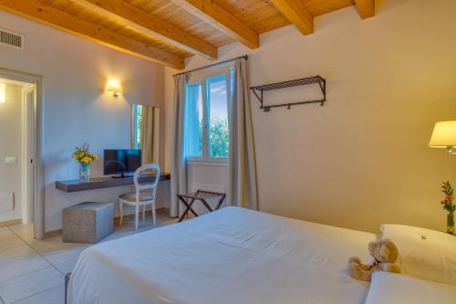 een slaapkamer met een wit bed en een bureau bij Agriturismo Corte Aurea in Desenzano del Garda