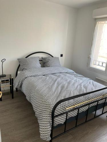 une chambre avec un lit avec une couette noire et blanche dans l'établissement Superbe appartement proche de tout, climatisé., à La Teste-de-Buch