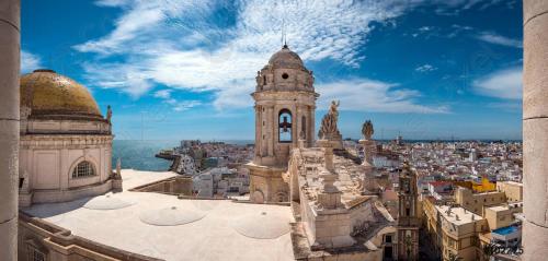 een uitzicht op een stad met een klokkentoren bij Piso luminoso cerca de playa in Cádiz