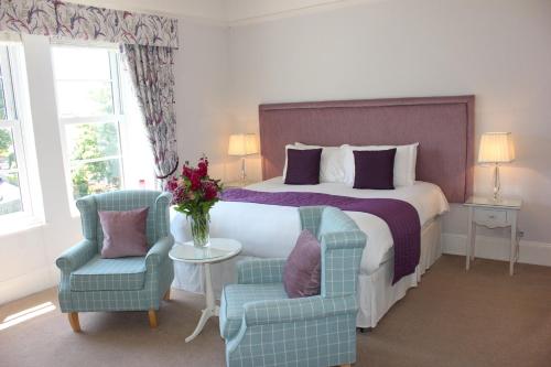 a hotel room with a bed and two chairs at Trafalgar House in Torquay