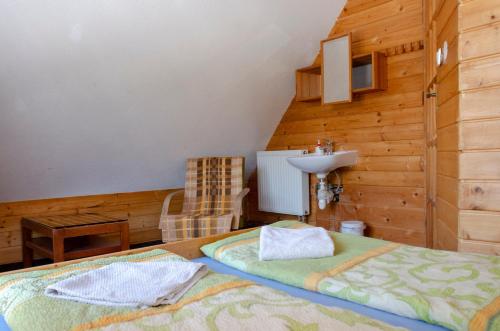 a bedroom with a bed and a sink in a room at Aqualand chata - Športové a výcvikové stredisko ZPS in Dedinky