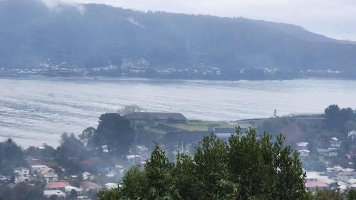 a large body of water with houses and a town at CABAÑAS ALTO BELLAVISTA NIEBLA in Niebla