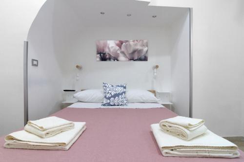 - une chambre avec un grand lit et des serviettes dans l'établissement Maison Du La Rua, à Naples