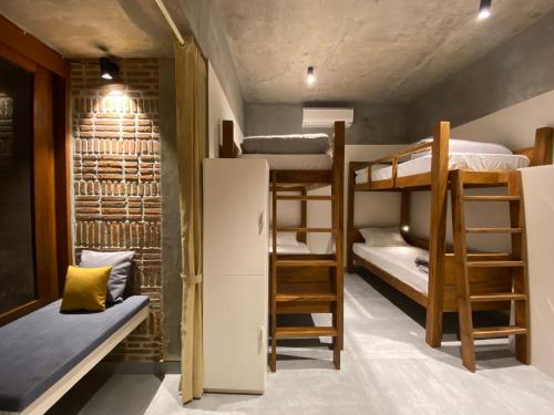 a dorm room with bunk beds and a refrigerator at Ostel In in Puducherry