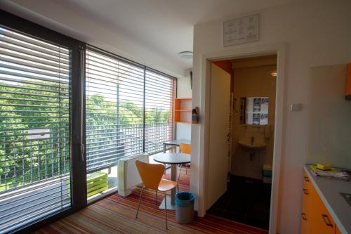 a kitchen with a large window and a table and chairs at Hostel Pekarna in Maribor