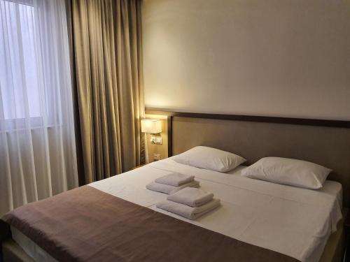 a hotel room with a bed with towels on it at Hotel Bono in Budva