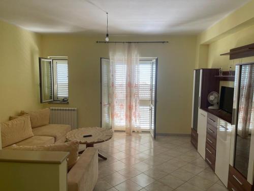 sala de estar con sofá y mesa en Confortevole e Luminoso Appartamento 100mq a Falerna con Vista sul Paese e sul Promontorio con Free WiFi Free Parking e Smart TV, en Falerna