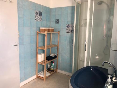 Łazienka z prysznicem i niebieską ścianą wyłożoną kafelkami w obiekcie Petite maison avec terrasse w mieście Jurançon