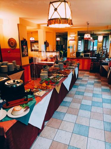a buffet line with plates of food in a restaurant at IHR Hotel Villa Emma in Canazei
