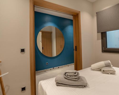 a bedroom with a mirror and a bed with towels at Centro Apartments in Heraklio Town