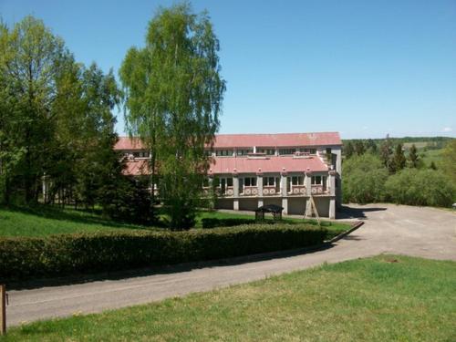 a large building with a red roof at Poilsio namai Šaltinelis in Plateliai