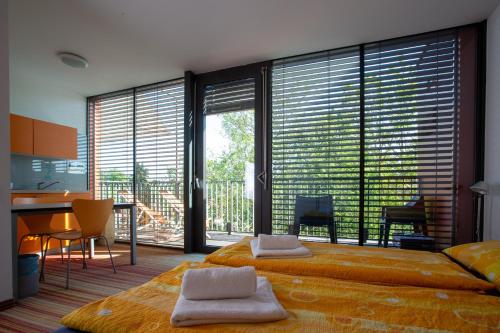 - une chambre avec un grand lit et de grandes fenêtres dans l'établissement Hostel Pekarna, à Maribor