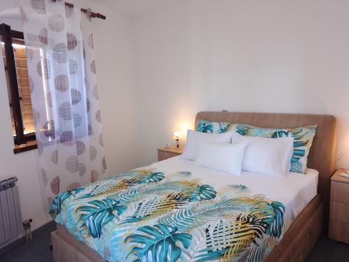 a bedroom with a bed with a tropical bedspread at Apartman Plava riba in Šibenik