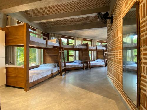 ポンディシェリにあるOstel Inのレンガの壁の客室で、二段ベッドが備わります。