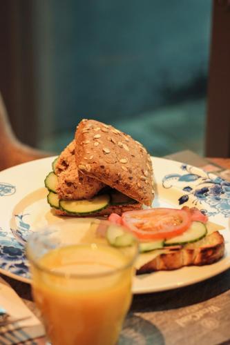 a sandwich on a plate next to a glass of orange juice at The Market Hotel in Groningen