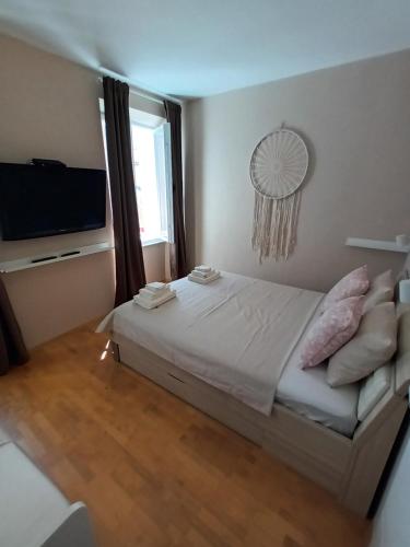 1 dormitorio con 1 cama y TV de pantalla plana en Family Sea Fun Apartment, en Koper