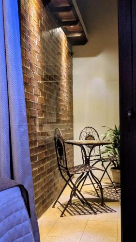 a patio with a table and a chair next to a brick wall at Hotel Posada de la Luna in Antigua Guatemala