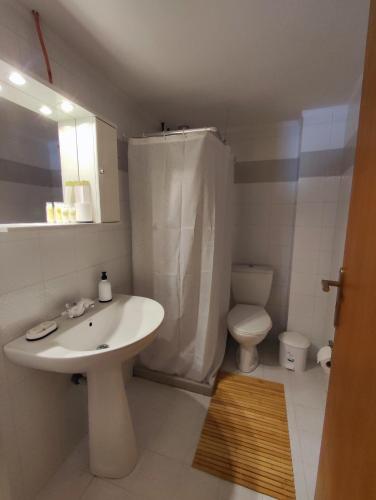 a bathroom with a white sink and a toilet at EM.MA HOME in Heraklio