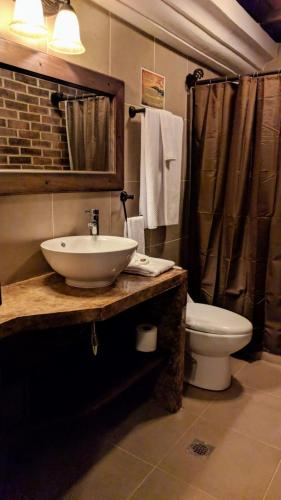 a bathroom with a sink and a toilet and a shower at Hotel Posada de la Luna in Antigua Guatemala