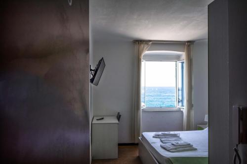 a bedroom with a bed and a window with the ocean at Hotel San Pietro Chiavari in Chiavari