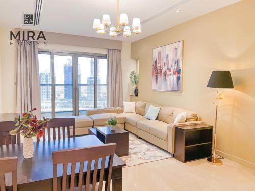 een woonkamer met een bank en een tafel bij Mira Holiday Homes - Lovely 1 bedroom apartment in Downtown in Dubai