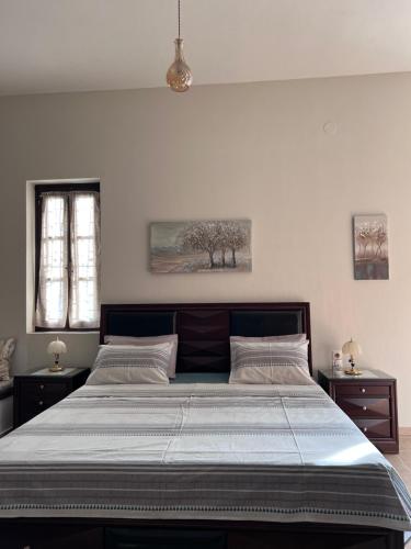 a large bed in a bedroom with two night stands at GRAND Boutique Studios in Afissos