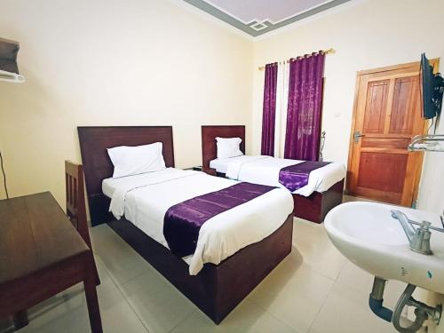 Llit o llits en una habitació de Hotel Manggala Syariah