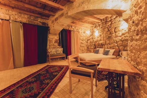 a room with a bed and a table and chairs at Pinhan Cave Suites in Uçhisar
