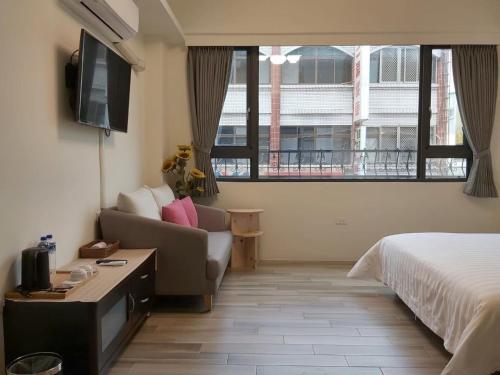 Habitación de hotel con cama, sofá y TV en JINGTONGYULI BnB, en Yuli