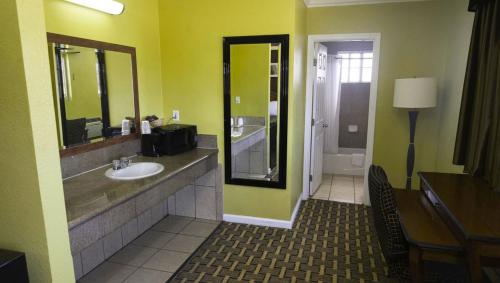 y baño con lavabo y espejo. en Kings Motel Inglewood en Inglewood