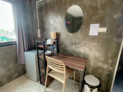 a table with a chair and a mirror on a wall at Taweehome hotel in Phra Nakhon Si Ayutthaya