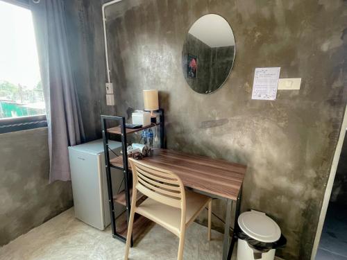 大城Taweehome hotel的桌子、椅子和墙上的镜子